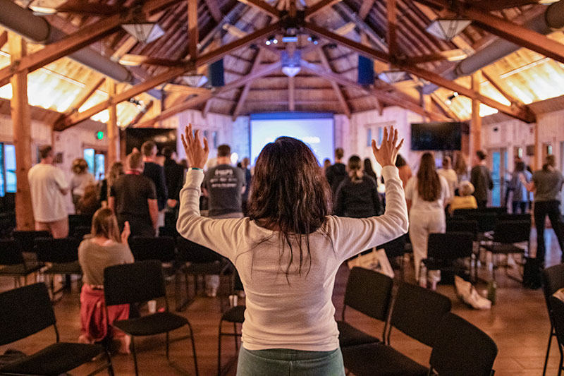 A woman raises her hands in worship at last year's retreat