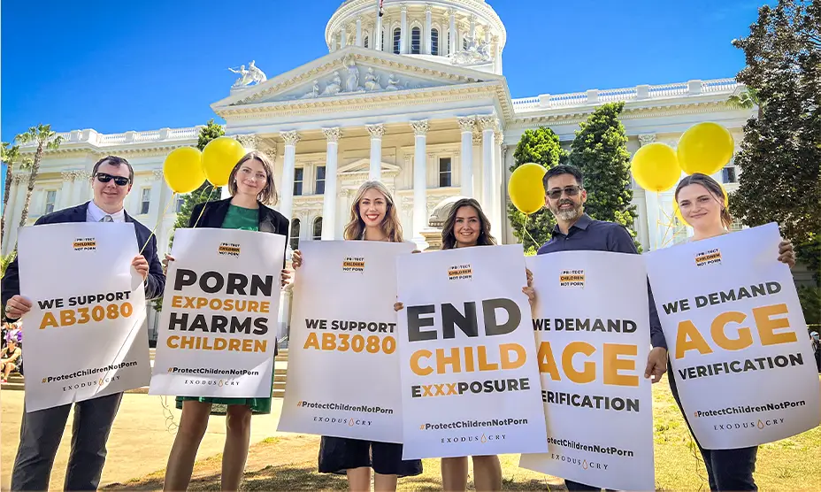 A team from Exodus Cry holds up protest signs outside of the California Capitol Building