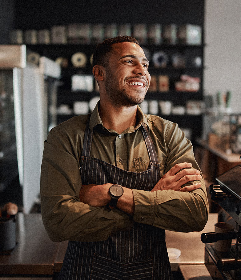 Smiling business owner looks out on his coffee shop